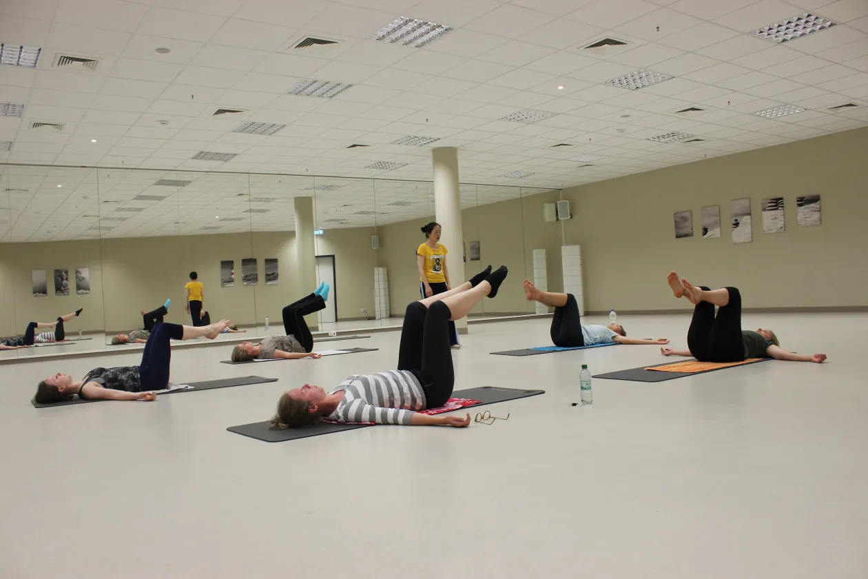 Fünf Personen liegen auf dem Rücken und machen Kraftübungen mit ihrem Körper