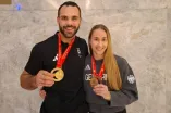 Isabell Thal with her teammate Lennart Sass. Both show their medals to the camera.
