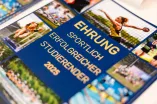 Die Urkunde für die Sportlerehrung 2025 mit vielen Bildausschnitten aus dem Wettkampfjahr