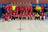 The male and female handball players are standing and sitting in and around a handball goal with their coaches.