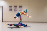 The picture shows two people performing an acrobatic routine together.