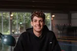 Schwimmer Cedric Büssing sitzt an einem Schreibtisch im Schwimmbad.