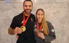 Isabell Thal mit ihrem Teamkollegen Lennart Sass. Beide zeigen Ihre Medaillen in die Kamera.