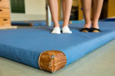 Zwei Paar Füße auf einer Sportmatte.