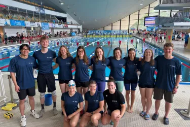Die 12 Teilnehmenden der Deutschen Hochschulmeisterschaften im Schwimmen posieren zum Teamfoto im Schwimmbad am Beckenrand