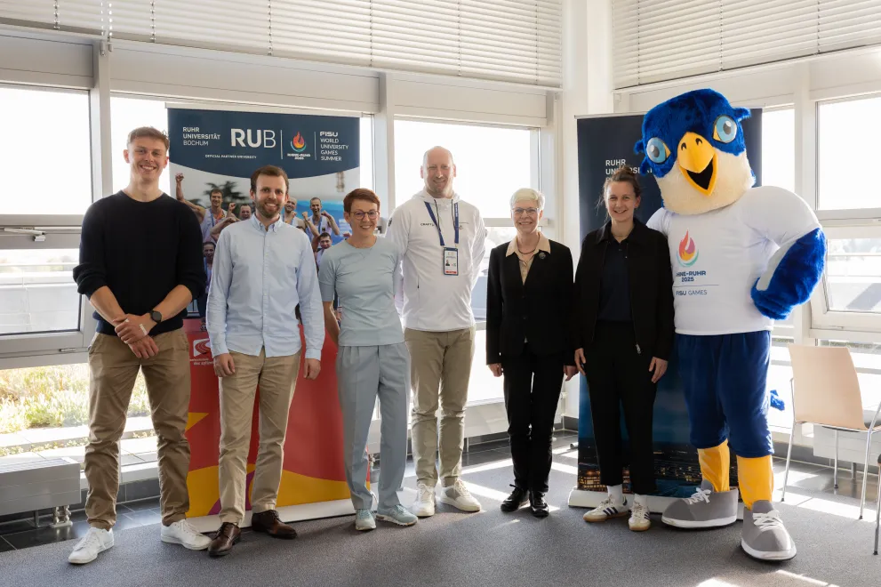 Freuen sich über die Kooperation (von links): Medizinstudent und Ruderer Paul Martin, Mirco Kreyenkamp und Ines Lenze vom Hochschulsport, Niklas Börger (CEO der Rhine-Ruhr 2025 FISU Games), Prorektorin Kornelia Freitag, Sina Diekmann (Chief Sports Officer) und Maskottchen Wanda
