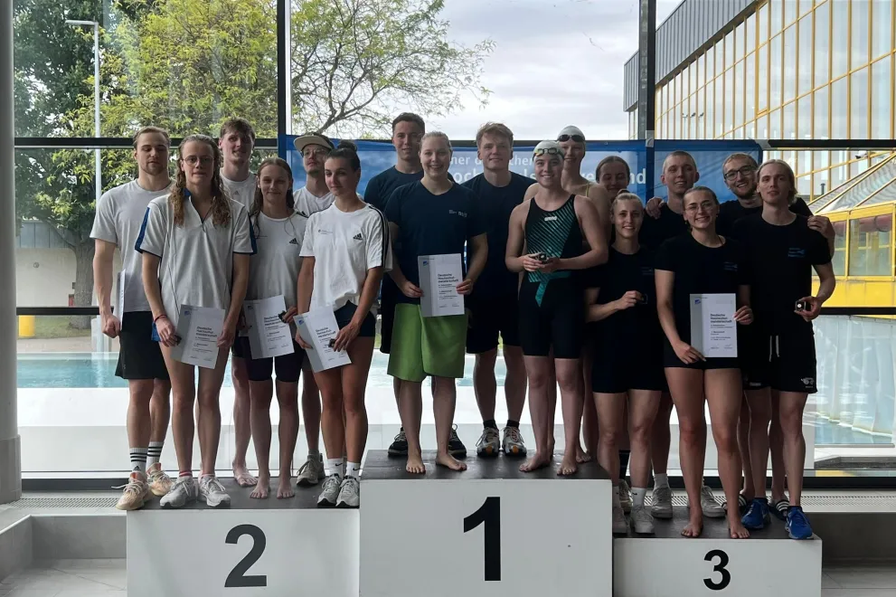 Die 6x50m Schmetterling Mixed Staffel steht zusammen auf dem Siegerpodest