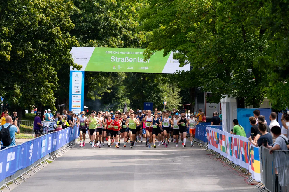 Die Läufer*innen des Straßenlaufs rennen aus dem Startbereich los.