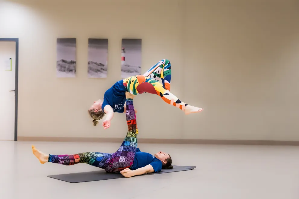 The picture shows two people performing an acrobatic routine together.